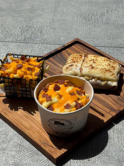 Gratinated French tacos with loaded cheese fries on a wooden board