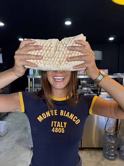 Customer holding a giant grilled French taco