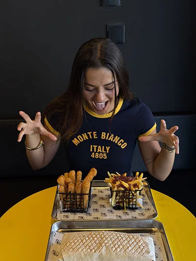 Customer excited in front of French tacos, fries and chicken tenders