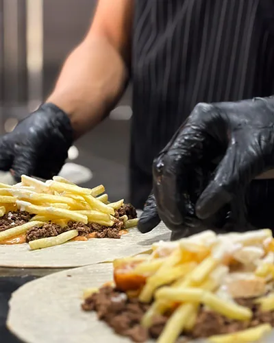 Making French tacos with fries and minced beef