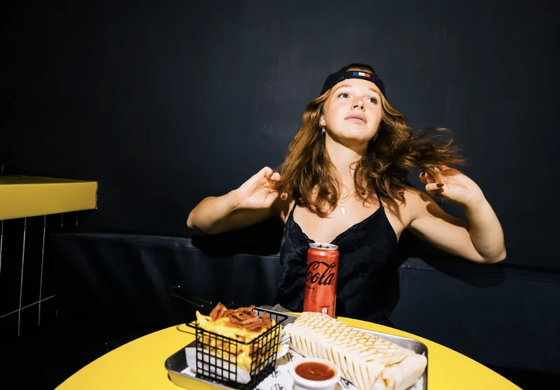 Customer at Bon Appétit with French tacos, loaded fries and a drink