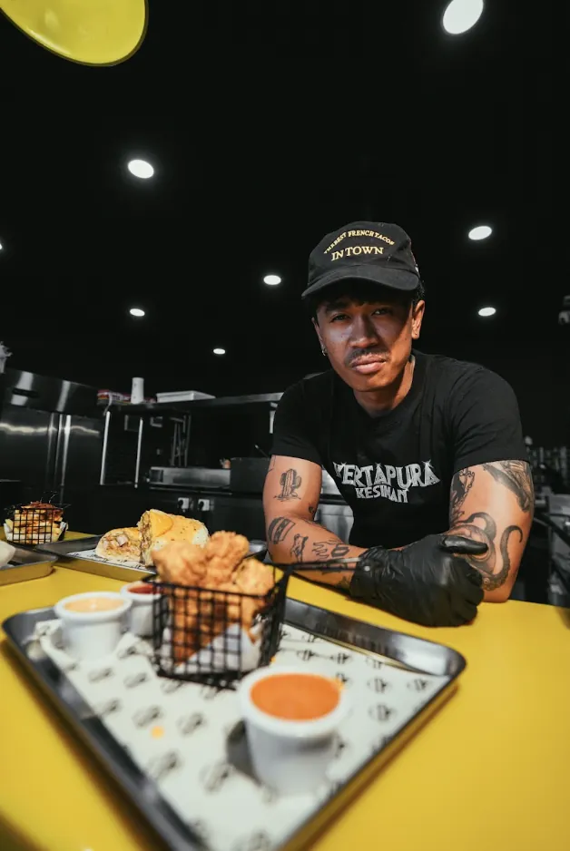 Bon Appétit kitchen team member with French tacos, chicken tenders and sauces
